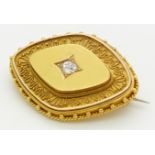 Victorian Etruscan Revival gold brooch set with an old mine cut diamond measuring approximately 0.
