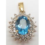 A 9ct gold pendant set with an oval cut topaz surrounded by diamonds