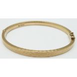 A 9ct gold bangle with raised textured detail, 30.9g