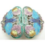 A silver buckle depicting flowers and moths set with enamel