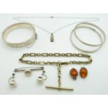 Three silver bangles, silver fob chain, pressed amber earrings and silver ingot