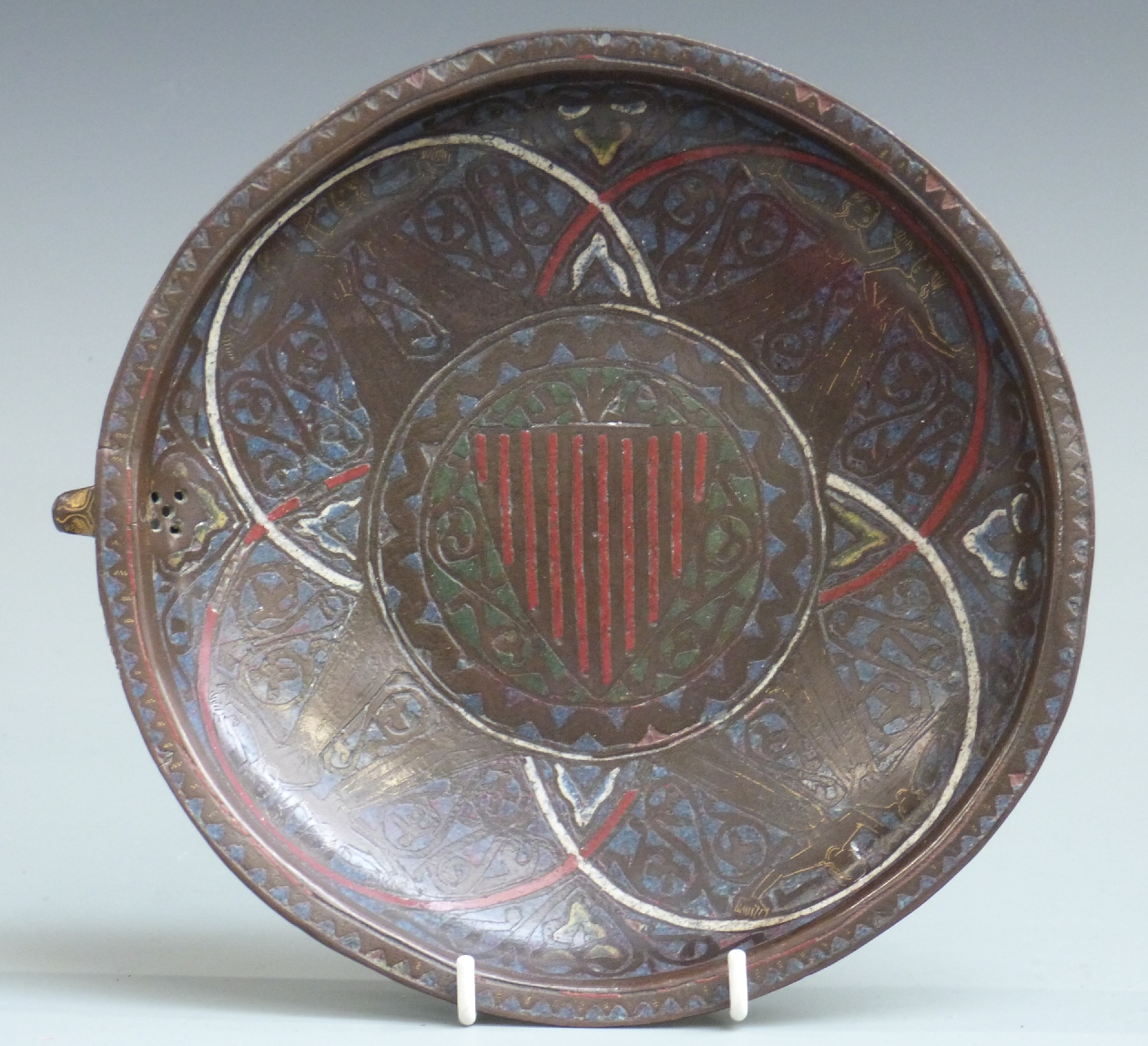 A 13thC French copper and polychrome champlevé enamel gemellion of typical shallow dished form,