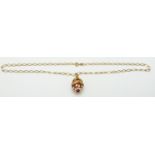 A 9ct gold chain with a silver gilt enamel egg pendant, 3.2g