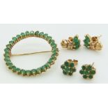 A 9ct gold circular brooch and two pairs of 9ct gold earrings, all set with emeralds