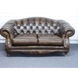 Chesterfield club style sofa finished in chestnut brown / tan leather with turned legs and brass cup