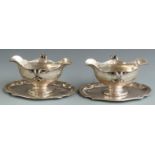 A pair of late 19th or early 20th century German white metal twin handled double ended sauce boats