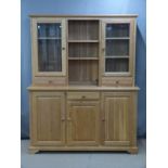 Modern light oak dresser, the top having shelves flanked by glazed display cupboards with drawers