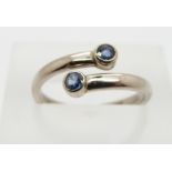 An 18ct white gold ring set with two sapphires, 3.2g