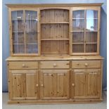 CHARITY Pine dresser, the top having open shelves flanked by glazed display cupboards, the base