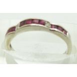 An 18ct white gold ring set with square step cut rubies and four diamonds, 2g, size L