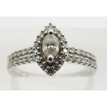 A platinum ring set with a marquise cut diamond surrounded by round cut diamonds, total