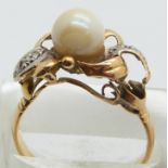 A yellow metal ring set with a pearl and diamonds, 3.8g, size P