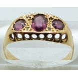 An 18ct gold ring set with three garnets, Birmingham 1919, in original box, 2.6g, size O