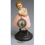 Cast iron figural clock in the form of a lady holding a clock, with automaton moving eyes, 30cm