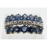 A 14k white gold ring set with a row of round cut diamonds and two rows of cornflower blue