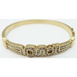 An 18ct gold bangle set with diamonds in an abstract design, 28.7g