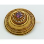 Victorian Etruscan Revival gold brooch set with a cushion cut garnet surrounded by seed pearls