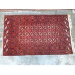 Turkoman rug with three lines of gul details on deep red ground within a geometric border, 125 x