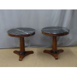 A pair of walnut and mahogany console tables set with circular black-marble tops and ebonised