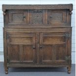 An antique country oak court cupboard with carved decoration, the top frieze carved with date, 140 x