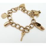 A 9ct gold curb link charm bracelet with five charms, 16.7g