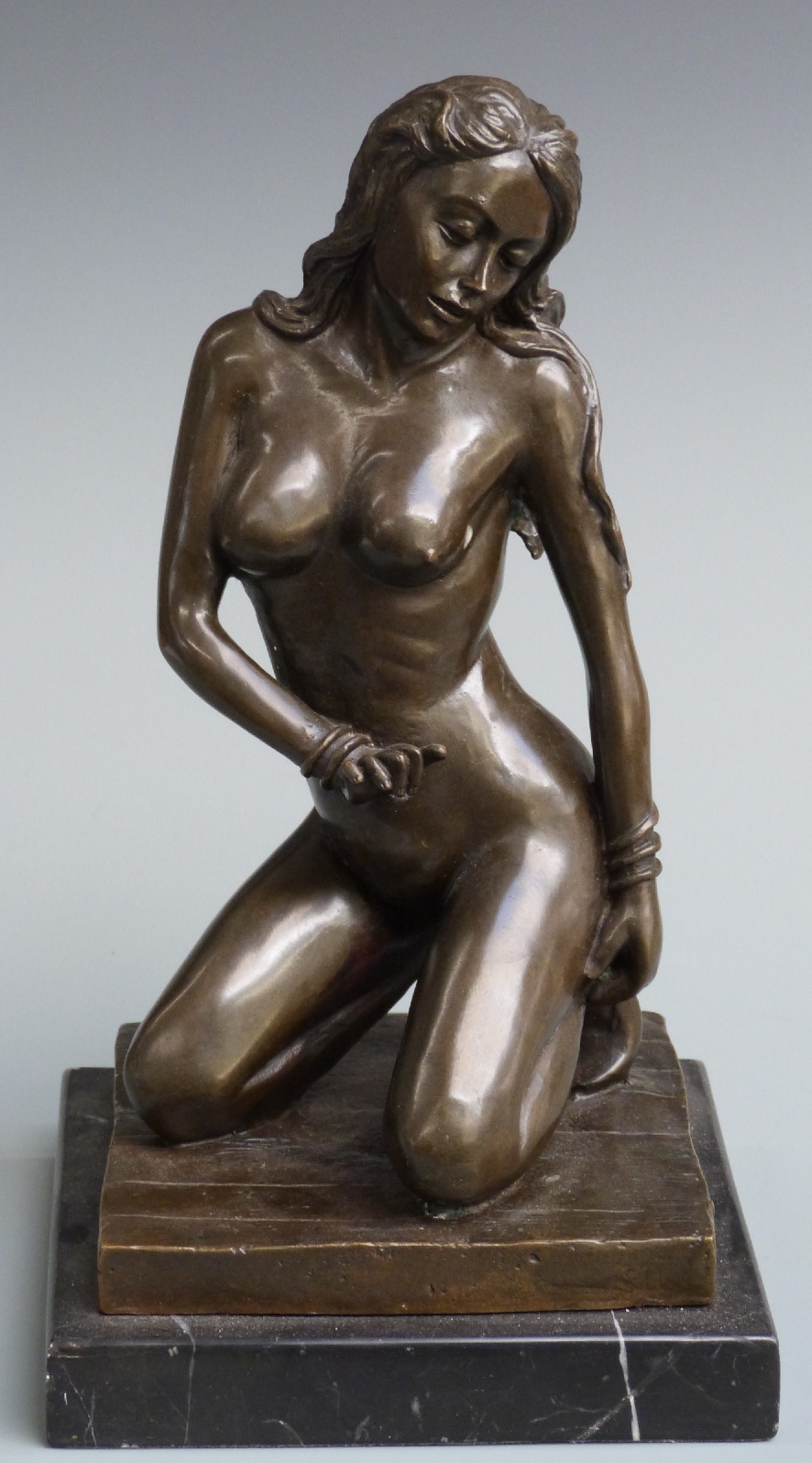 A bronze model of a nude lady kneeling, set on marble plinth, approximately 32cm tall