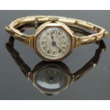 9ct gold ladies wristwatch with Arabic numerals and gold highlighted silver dial, on 9ct gold