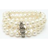 A three strand pearl bracelet with a white gold clasp set with diamonds in three clusters