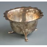 George V hallmarked silver sugar bowl with shaped edge and raised on three feet, marks rubbed but