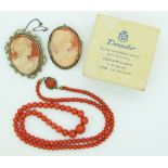 Two silver brooches set with cameos in a cameo box from Rome and a coral necklace, 20g.