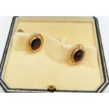 A pair of 9ct gold cufflinks set with an oval cut garnet to each, 7.5g