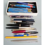 A collection of pens and writing instruments including Parker Duofold.