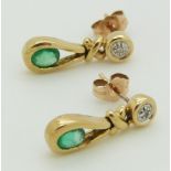 A pair of 9ct gold earrings set with an oval cut emerald and diamond to each