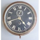 Brass ship's bulkhead clock with black Roman dial and Arabic secondary seconds, marked 'Made in