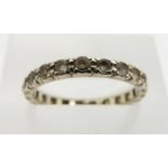 A white metal eternity ring set with paste, size M, 1.9g.