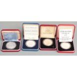 Four 1980s Royal Mint cased silver commemorative crown-sized coins to include a proof Charles and