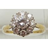 An 18ct gold ring set with a cluster of diamonds, the centre diamond measuring approximately 0.75ct,