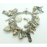 A silver charm bracelet with a large quantity of charms including ladybird, St Christopher, dog,