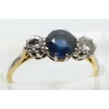 An 18ct gold ring set with a round cut sapphire measuring approximately 1.14ct and two round cut