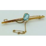 A 15ct gold brooch set with an emerald cut aquamarine, length 5cm