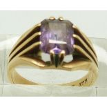 A 9ct gold ring set with an emerald cut purple sapphire, 5.2g, size O