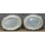 A pair of decorative oval mirrors with silver sunburst style frames, each 97 x 80cm