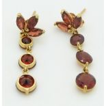 A pair of 14k gold earrings set with garnets