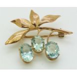 A gold brooch/ pendant set with three oval aquamarines in a foliate design, 4.9g