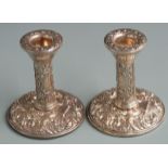 Pair of hallmarked silver repoussé decorated candlesticks with vacant cartouches to stems,