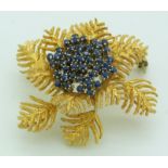 An 18ct gold brooch in the form of fern leaves set with sapphires in a cluster, 4cm, 13.1g