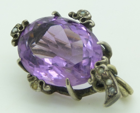 A silver brooch set with an oval cut amethyst and seed pearls, 3 x 2.2cm