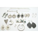 A collection of silver earrings including novelty fish and other examples and a charm bracelet