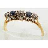 An 18ct gold ring set with three diamonds and two sapphires in a platinum mount, 1.9g, size K