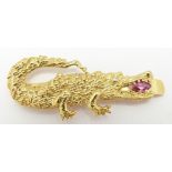 An 18ct gold crocodile clip set with a marquise cut ruby and a diamond eye, 5.8g